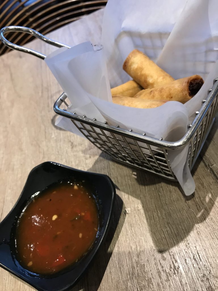 basket of lumpia spring rolls and dish of dipping sauce