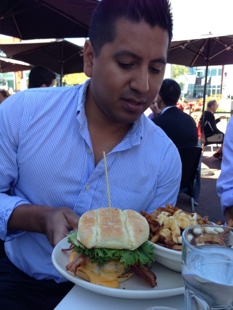 Astounded man looks at large Burgers and Poutine in Laval