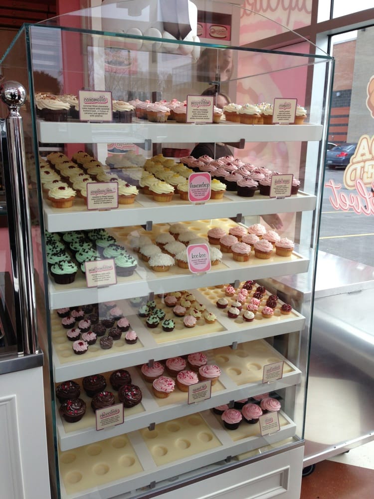 cupcake flavours on display behind glass on a vertical rack