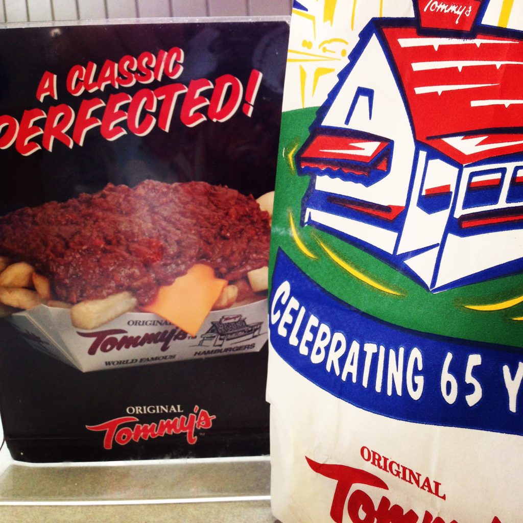 chili cheese fries ad at the table with a paper bag for Tommy's Hamburgers in Fountain Valley