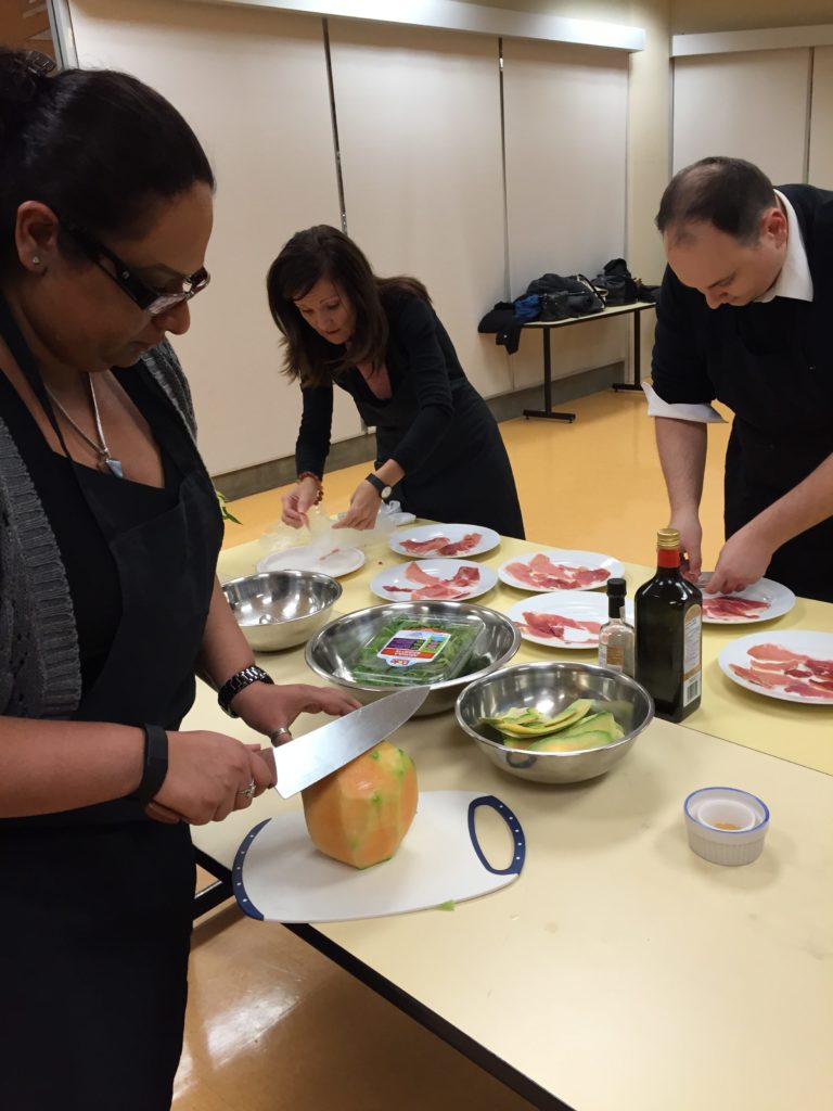 3 people work on making the salads for the cooking class