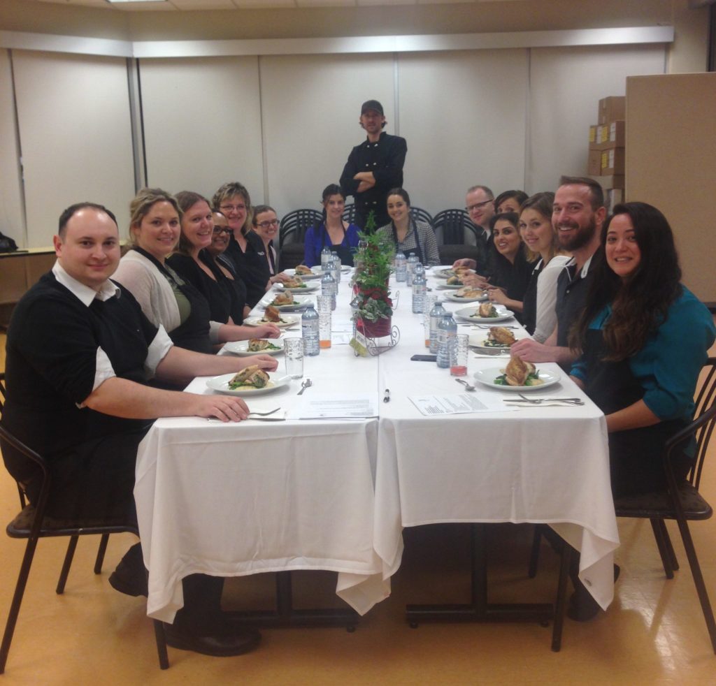 the whole group sits down at the end of the cooking class for a photo