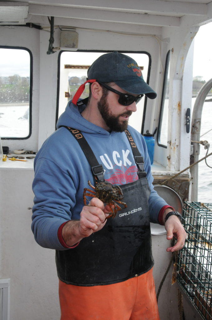 man holds crab in his hand