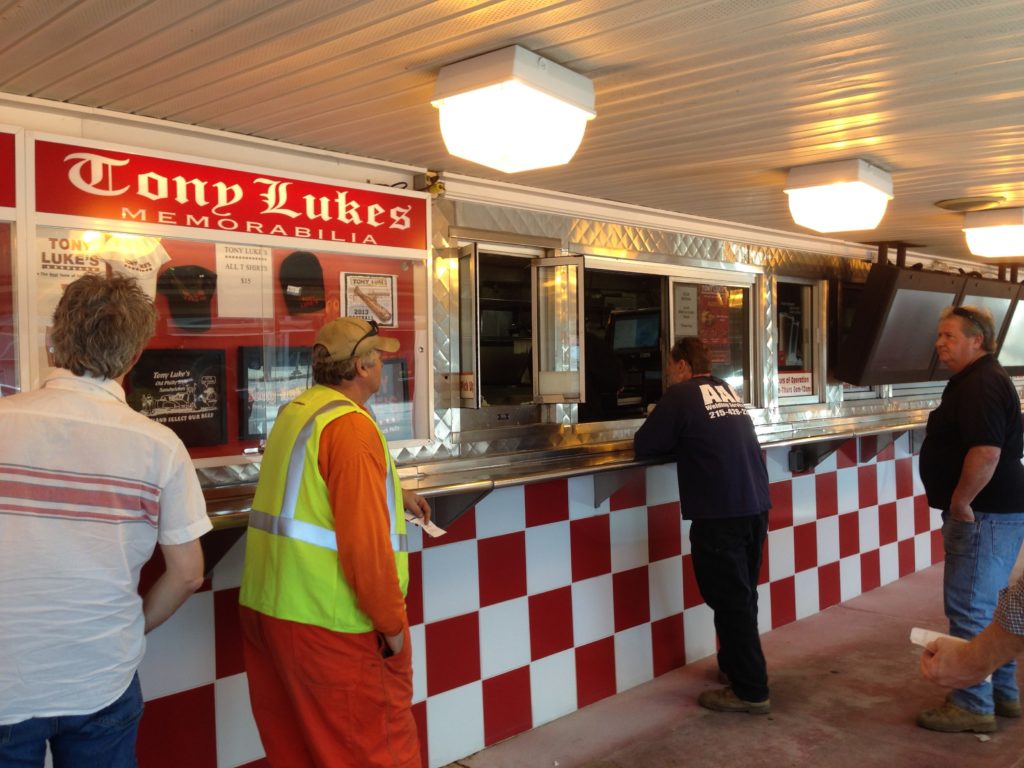 man in safety vest and others wait for their cheesesteak in Philadelphia