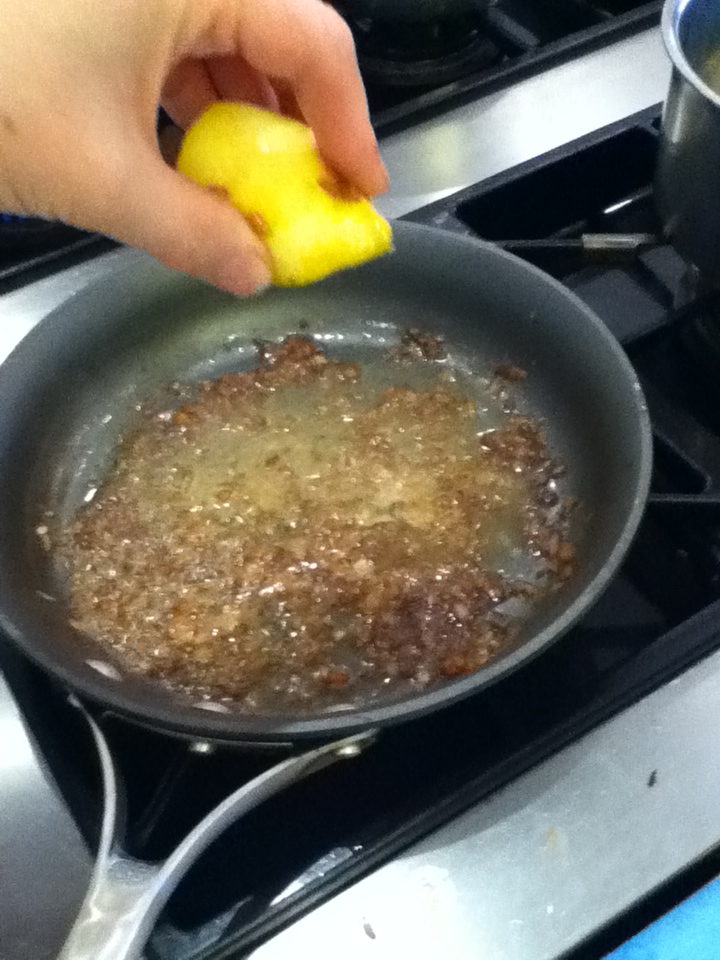 squeezing lemon over a pan