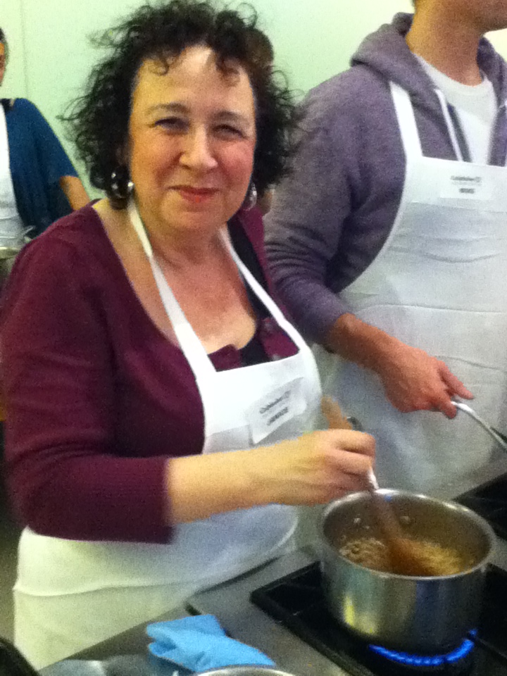 woman stirs risotto at girls' night out cooking class