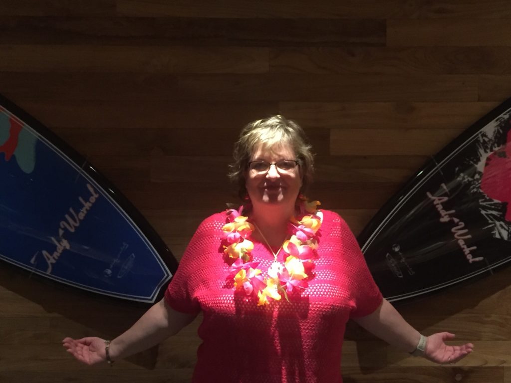woman posing with 2 Andy Warhol surfboards at Duke's La Jolla
